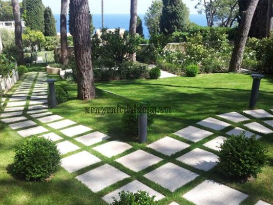 Gạch lát sân họa tiết độc đáo kết hợp với cây cảnh hai bên tạo điểm nhấn cho lối đi trong vườn.